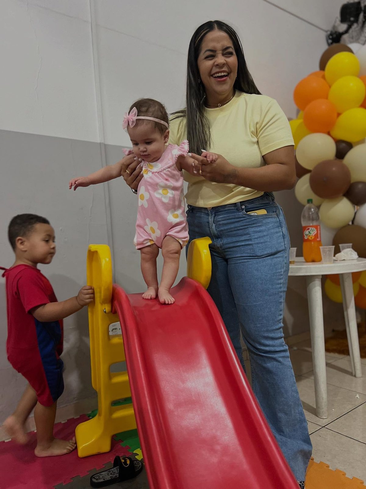 Criança brincando no escorregador com uma adulta