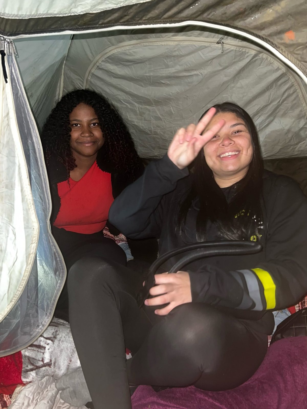 Duas adolescentes sorrindo em um acampamento